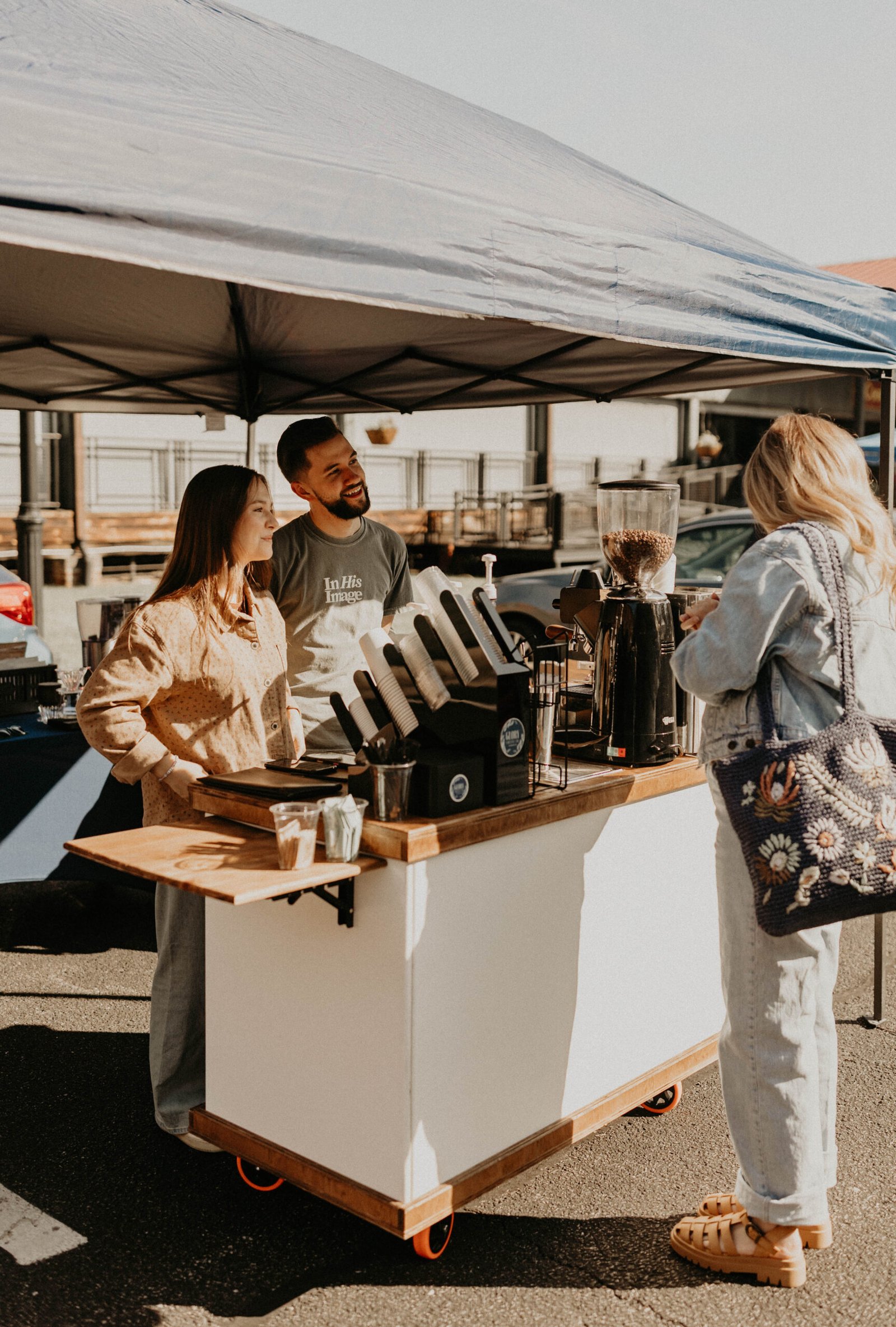 Glory Coffee team serving a guest at the outdoor coffee cart